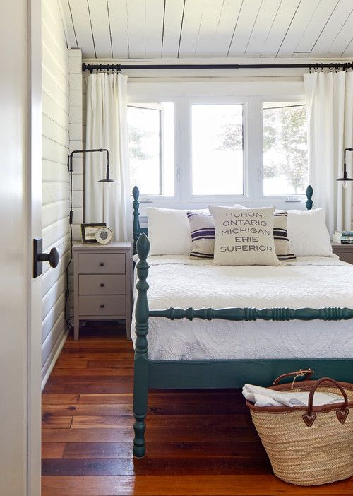 a bedroom with white walls and wood floors