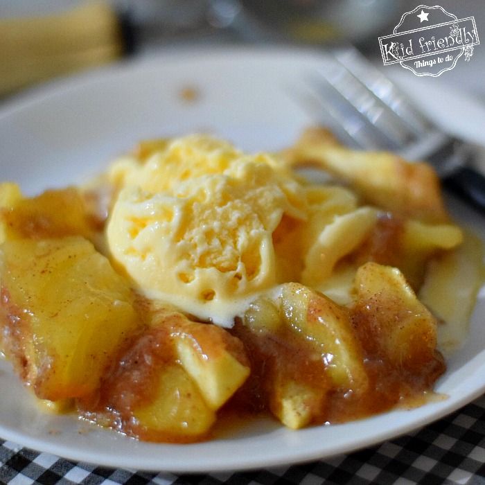 a white plate topped with pasta covered in sauce and cheese on top of a checkered table cloth