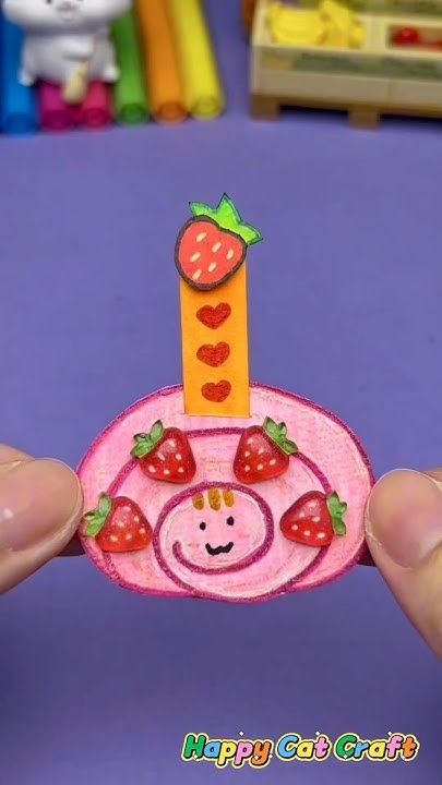 someone is holding up a small card with a giraffe and strawberries on it