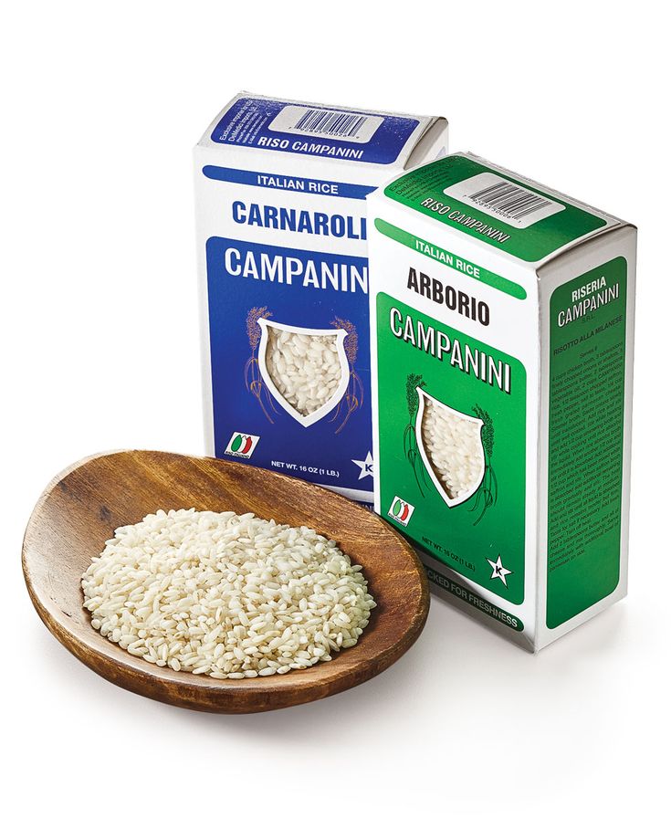 a wooden bowl filled with white rice next to a carton of garbaro