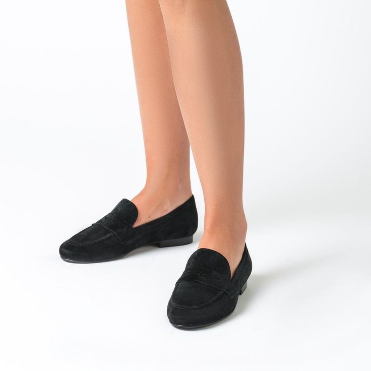 The Taylor is our new City-Style woman's loafer, sewn by hand in luxuriously soft suede. Its rubber sole is a key comfort feature. Go preppy-chic in this comfort-inpired black penny loafer of impeccable fit, craftsmanship and quality. Split Suede upper Leather lining and insole Rubber sole .5 inch heel Made in Spain Black Suede Loafers For Business Casual, Black Slip-on Loafers With Suede Lining, Slip-on Suede-lined Moccasins For Work, Suede Moccasins With Flat Heel For Business, Suede Moccasins For Business, Business Suede Moccasins With Flat Heel, Suede Flats With Rubber Sole For Work, Suede Loafers With Leather Sole And Flat Heel, Suede Loafers With Leather Footbed For Work