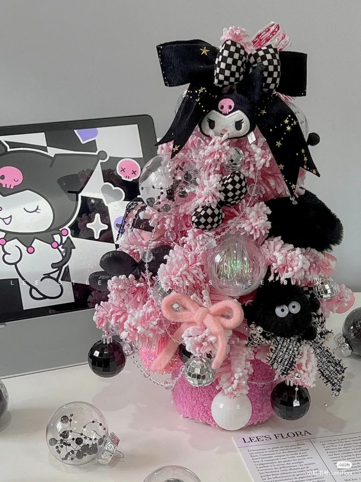 a pink christmas tree with black and white ornaments