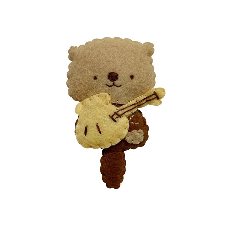 a teddy bear holding a piece of bread in its paws and wearing a hat with an instrument on it's back