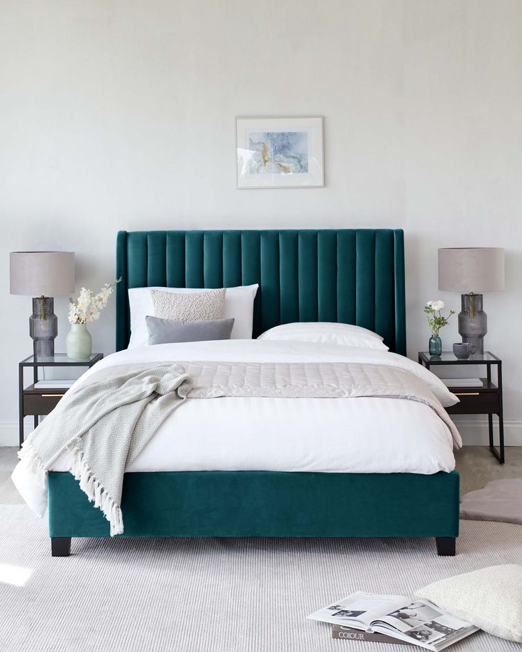 a bedroom with white walls and green headboard