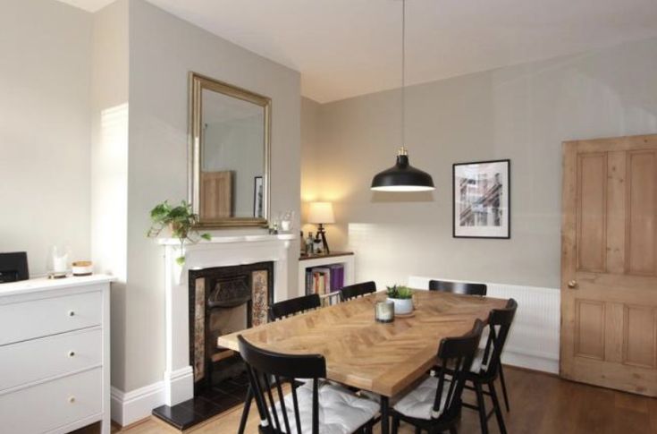 a dining room table with chairs and a fire place in the corner next to it