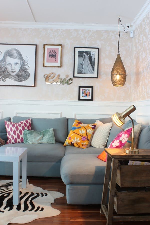 a living room filled with lots of furniture and pictures on the wall above it's coffee table