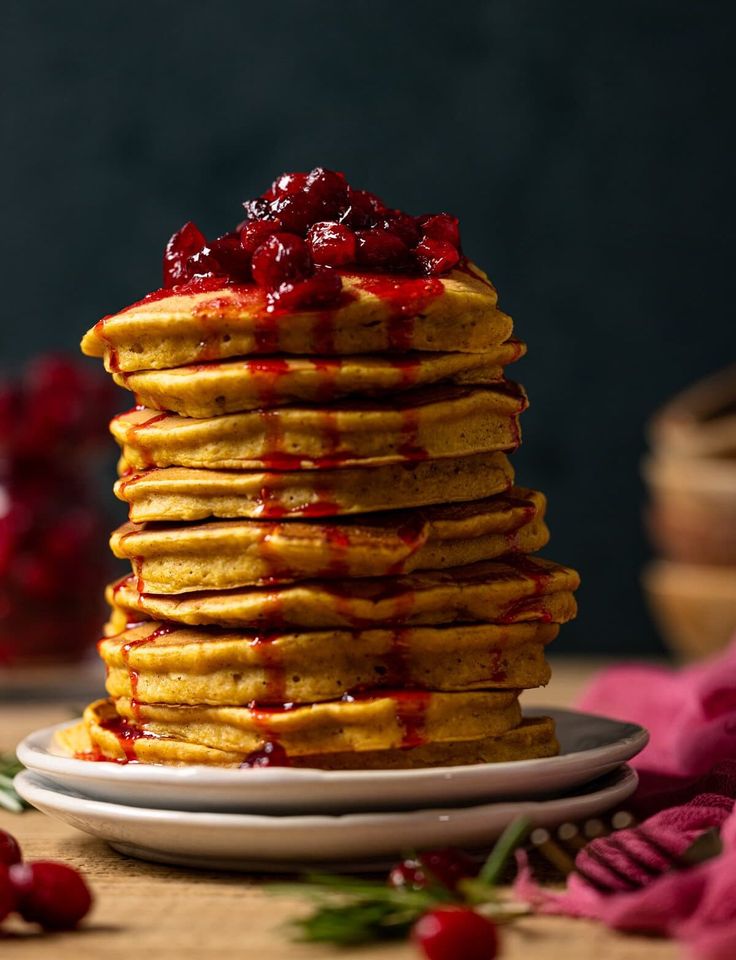 a stack of pancakes with cranberry sauce on top