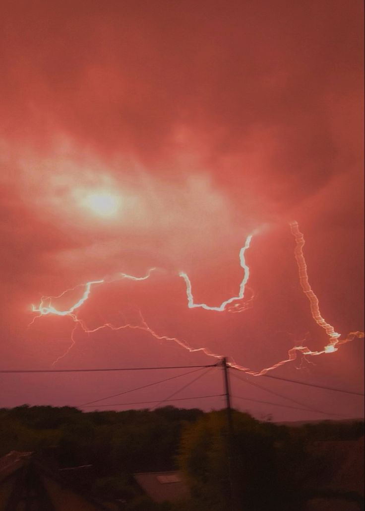 the sky is filled with lightning and it appears to be very pink in this photo