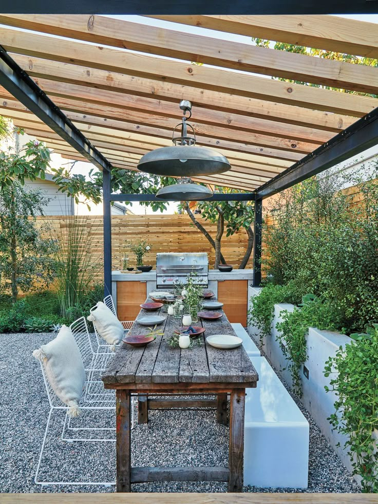 an outdoor dining area with wooden table and chairs