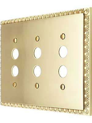 a gold plate with four holes in the middle and three circles on each side,