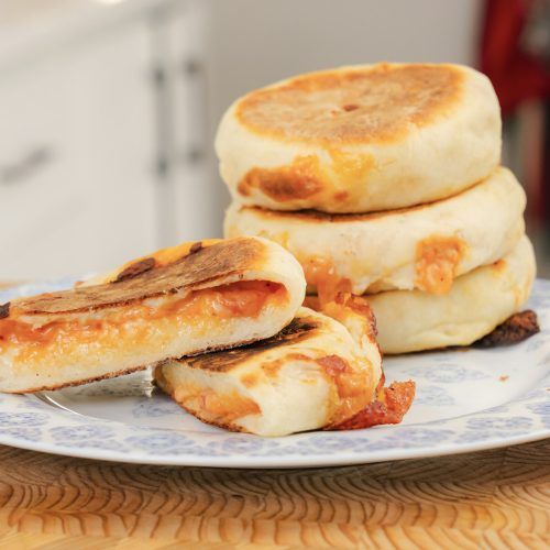 three pancakes stacked on top of each other on a blue and white plate with a knife