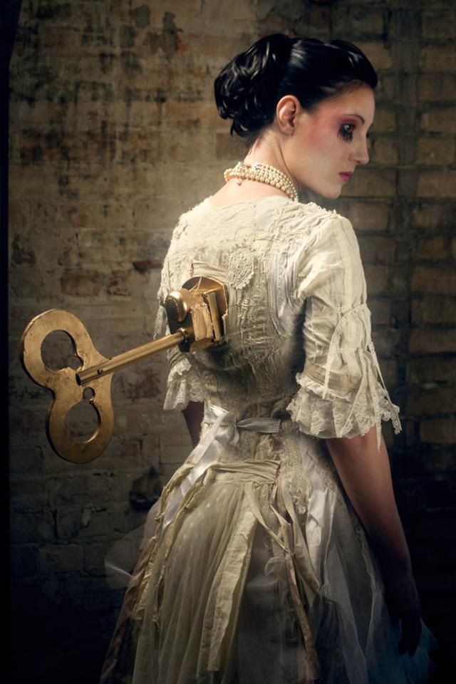 a woman in an old fashion dress holding a wrench