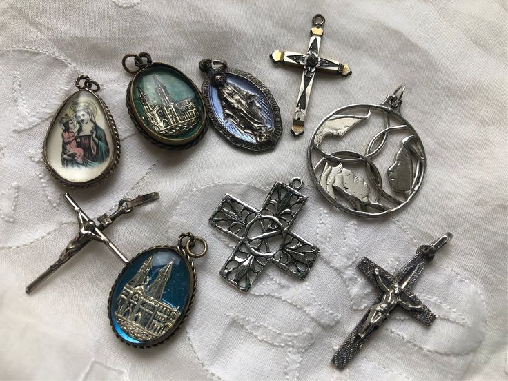 "These are old religious charms that can be put on a chain or charm bracelet. The largest circular one with Mary, Joseph and baby Jesus is marked sterling as is the square openwork cross. The charms encased in glass are silver plate and brass. The  other crosses are gold or silver plated.  All are included for the price. The circular charm is 1.25\" in diameter and all are at least 1\" long." Antique Nickel-free Cross Pendant Jewelry, Vintage Nickel-free Crucifix Jewelry, Spiritual Silver Jewelry Souvenir, Nickel-free Cross Pendant Spiritual Jewelry, Nickel-free Spiritual Cross Pendant Jewelry, Nickel Free Spiritual Cross Pendant Jewelry, Nickel-free Spiritual Cross Pendant, Vintage Sterling Silver Crucifix Jewelry, Silver Cross Jewelry With Charms