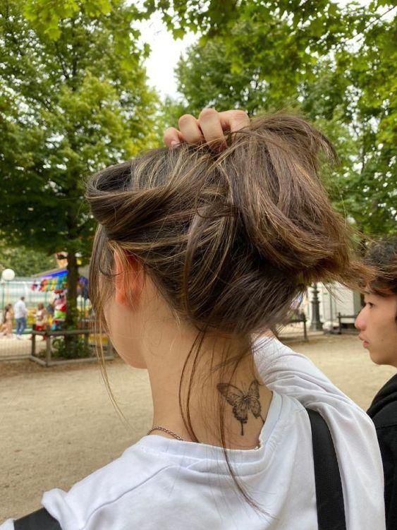 a woman with a tattoo on her neck standing next to another woman in a park