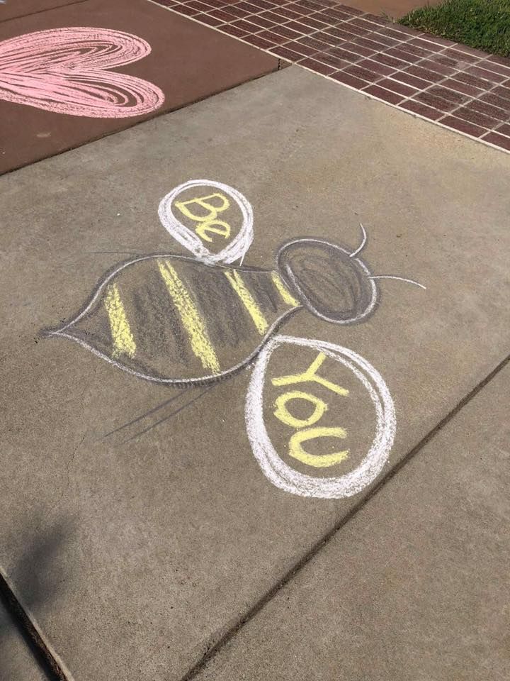 the sidewalk has been drawn with chalk and is decorated with an image of a bee