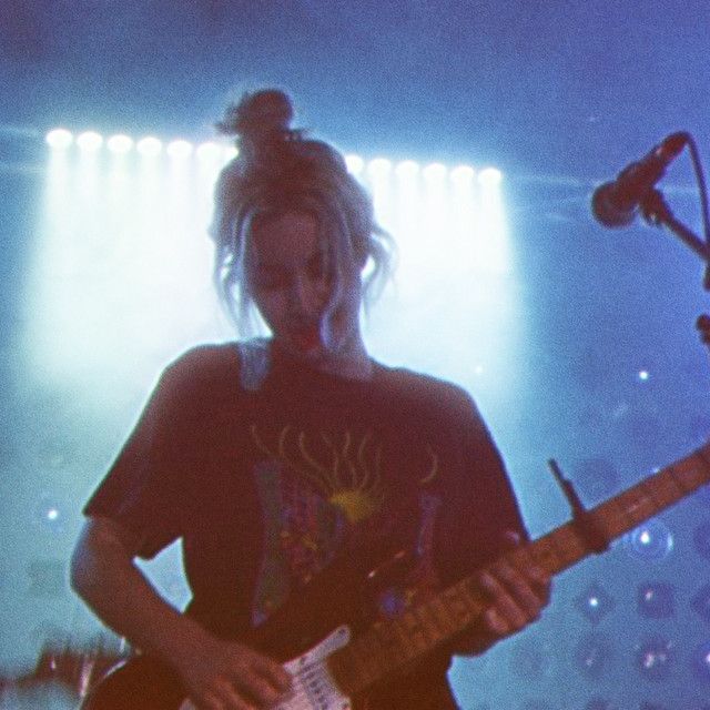 a woman playing guitar on stage at a concert