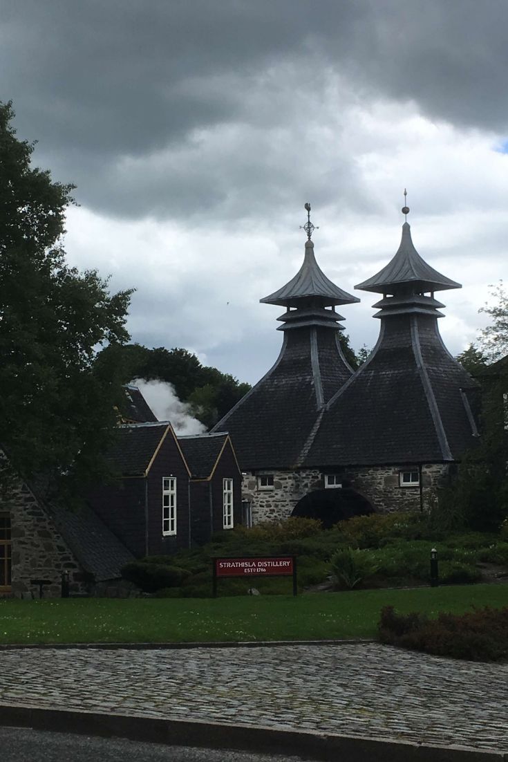 a couple of buildings that are next to each other in the grass and some trees