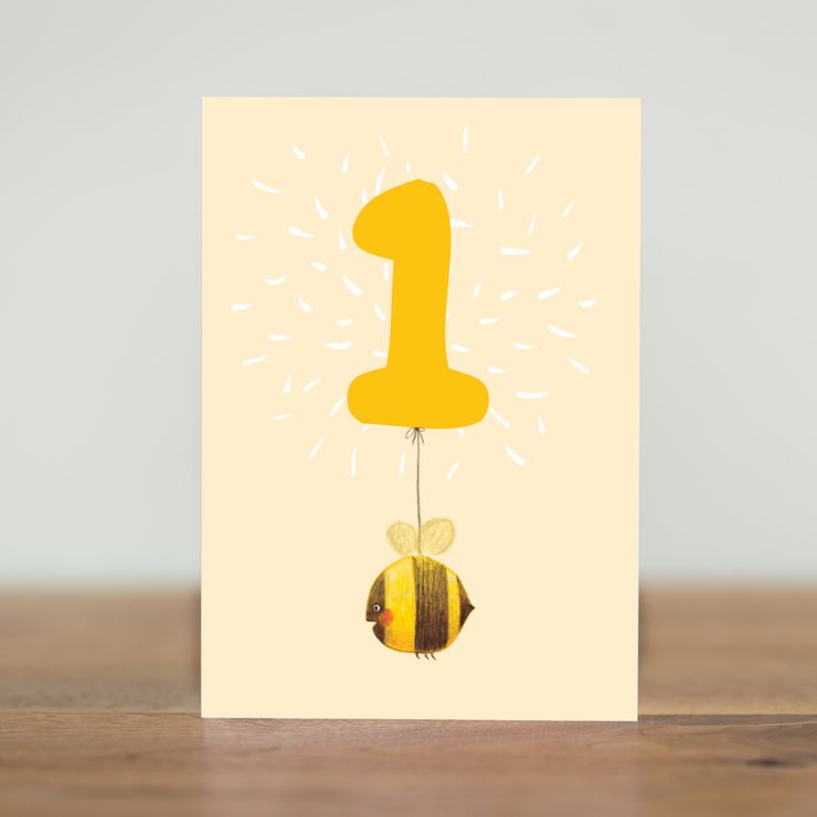 a card with a yellow number one hanging from it's side on a wooden table