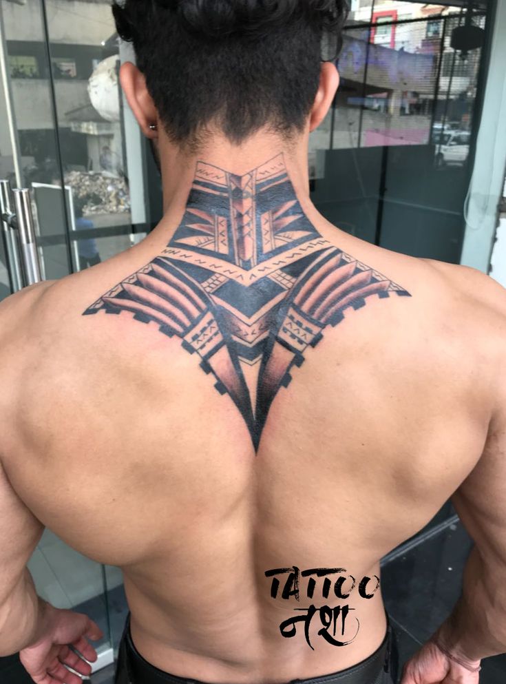 the back of a man with tattoos on his upper and lower part of his body