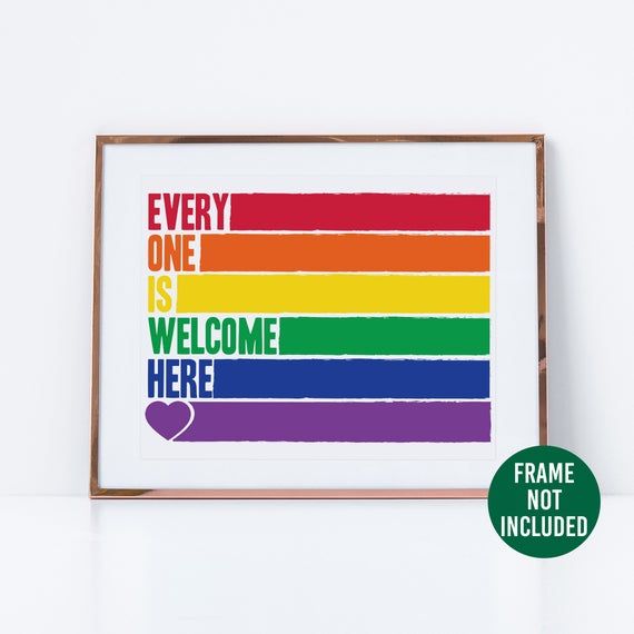 a framed poster with the words every one is welcome here in rainbow colors on it