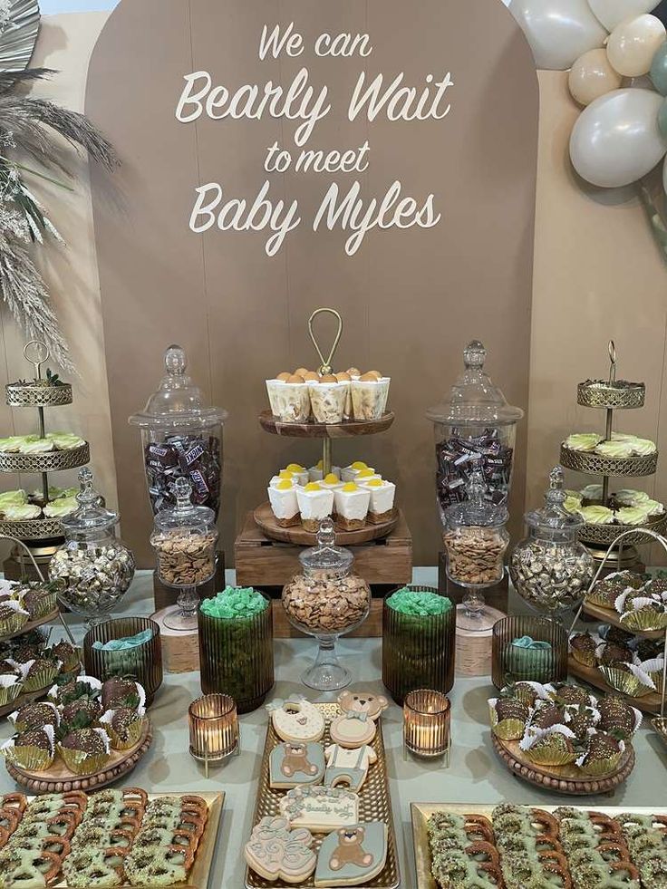 an assortment of desserts and sweets on display at a baby's first birthday party