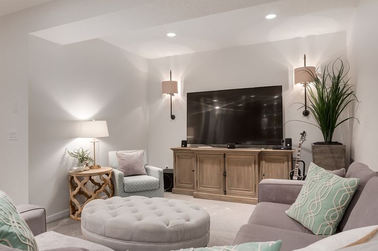 a living room filled with furniture and a flat screen tv mounted to the side of a wall