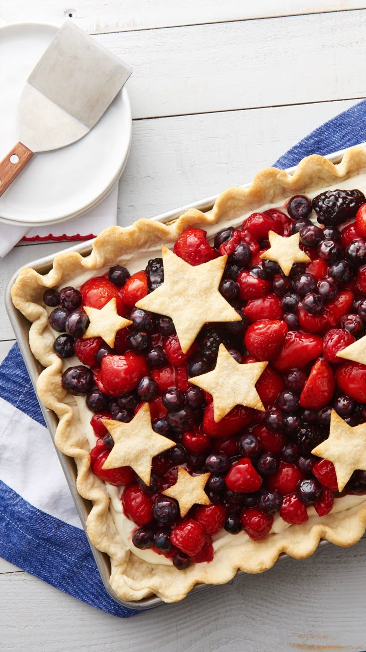 an american flag pie with berries and stars on top is ready to be served for the fourth of july