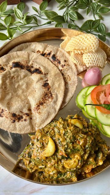 a metal plate topped with different types of food next to cucumbers and crackers