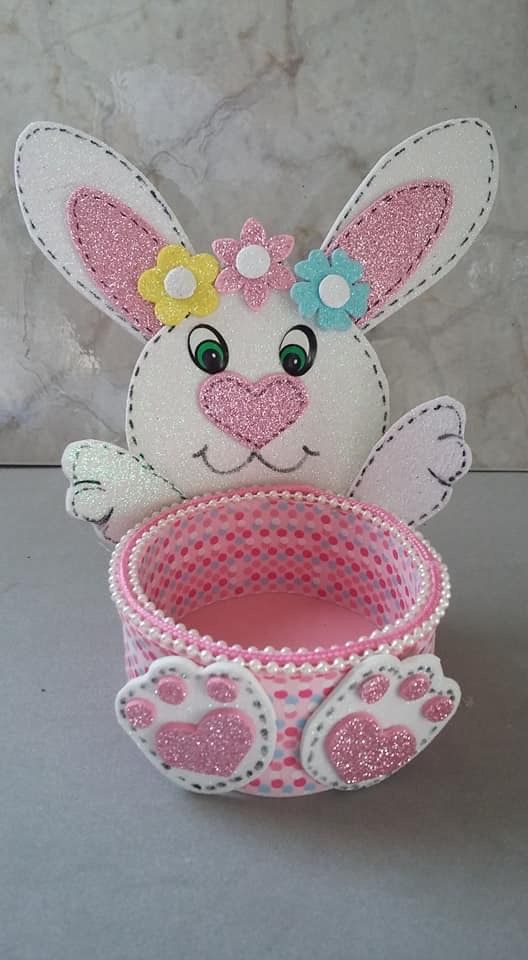 an easter bunny sitting next to a cup