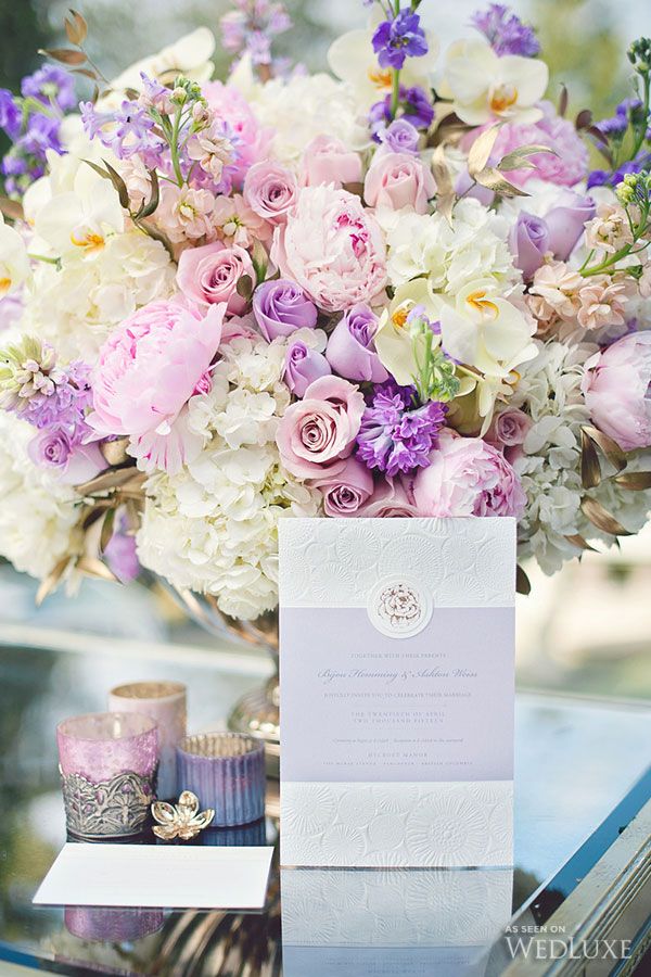 a vase filled with lots of purple and white flowers