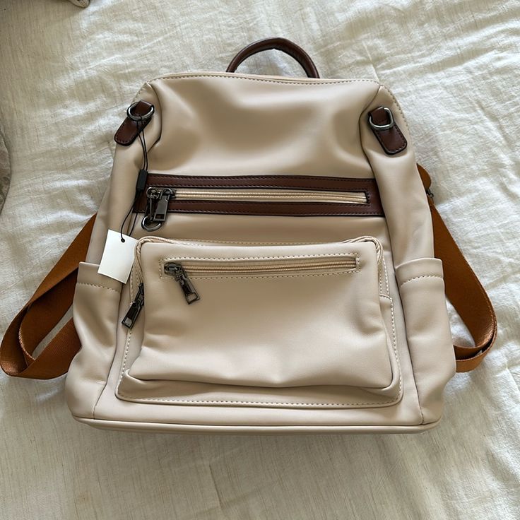 New With Tags Women’s Backpack Purse. Beige And Brown In Color. Comes With An Additional Strap To Use As A Crossbody. Faux Leather Material. Leather Backpack With Zipper Closure In Cream, Cream Leather Backpack With Zipper Closure, Casual Beige Leather Softback Backpack, Trendy Cream Backpack With Adjustable Strap, Everyday Cream Leather Backpack With Adjustable Strap, Cream Leather Backpack With Adjustable Strap, Casual Cream Backpack With Adjustable Strap, Casual Beige Leather Backpack For Everyday, Casual Beige Leather Everyday Backpack