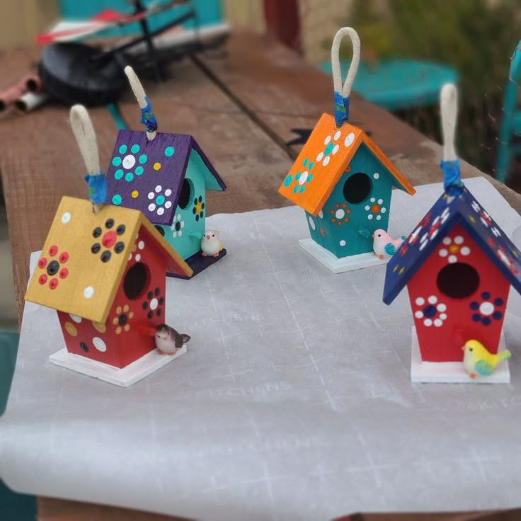 three colorful birdhouses are sitting on a table