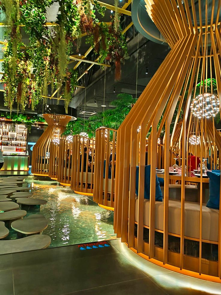 the interior of a restaurant with wooden booths and plants hanging from the ceiling