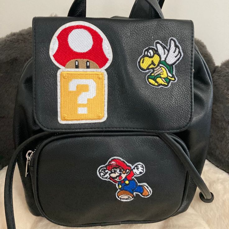 a black backpack with mario and other stickers on it