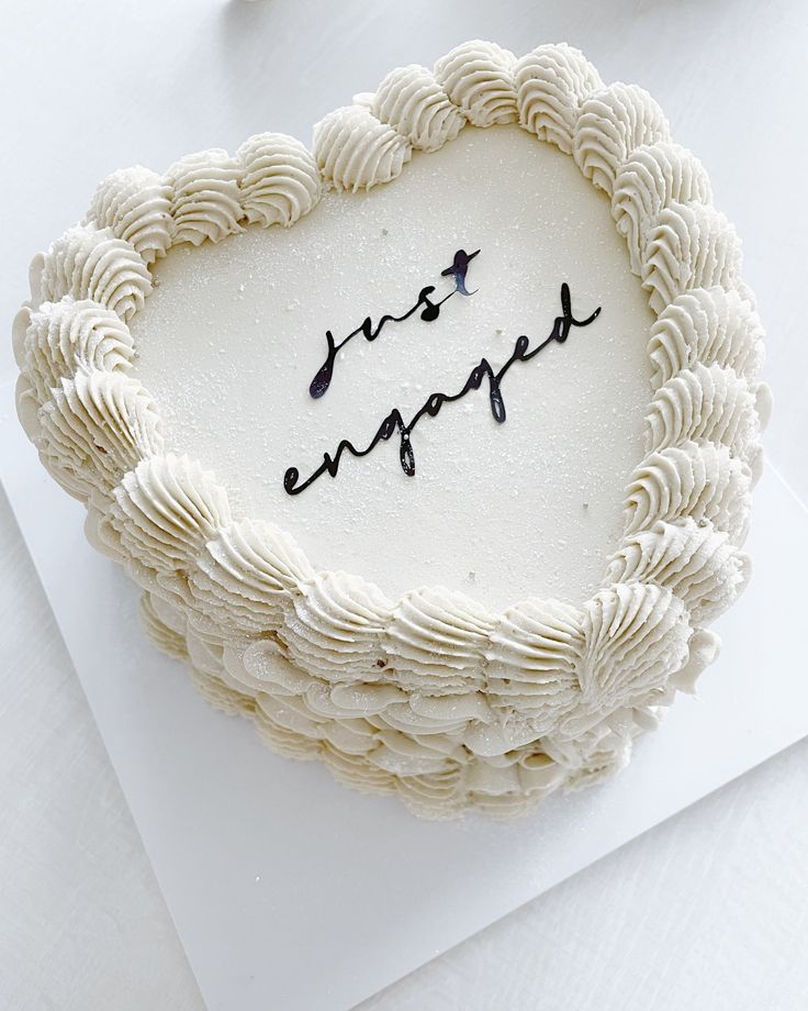 a white cake with writing on it sitting on top of a table