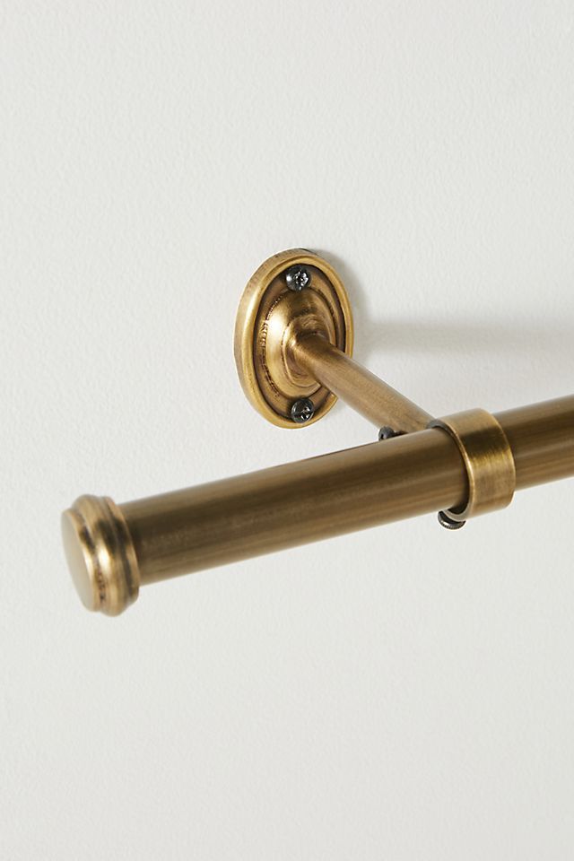 an antique brass toilet paper holder on a white wall with a gold handle and pull bar