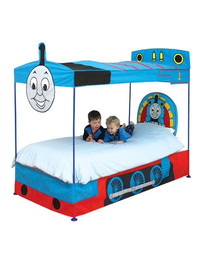 two children laying on a bed with thomas the tank engine canopy and headboard,