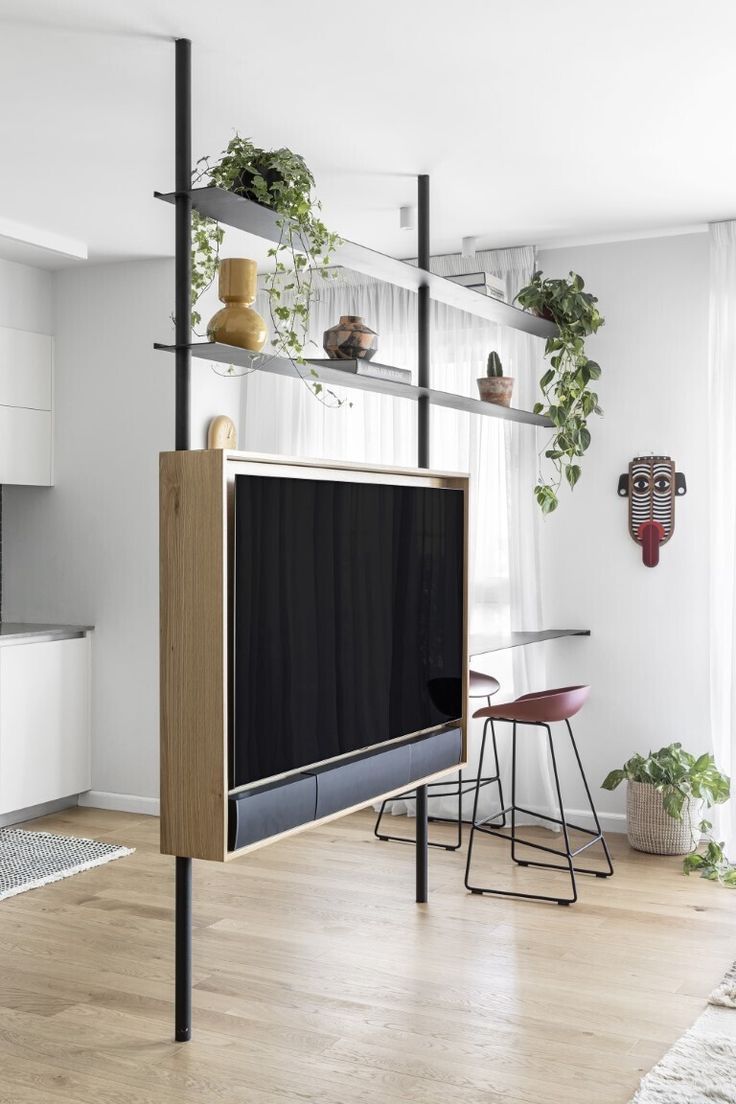 a living room filled with furniture and a flat screen tv mounted on a wall next to a window