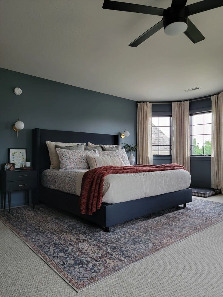 a bedroom with a large bed and ceiling fan in it's centerpieces