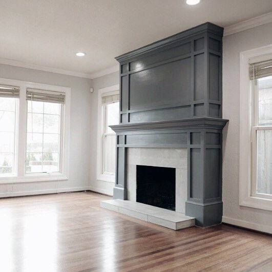 an empty living room with a fireplace and hardwood floors