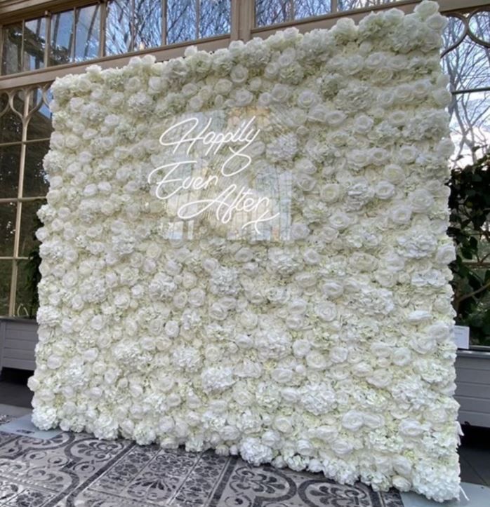 a large white flower covered wall in front of a window