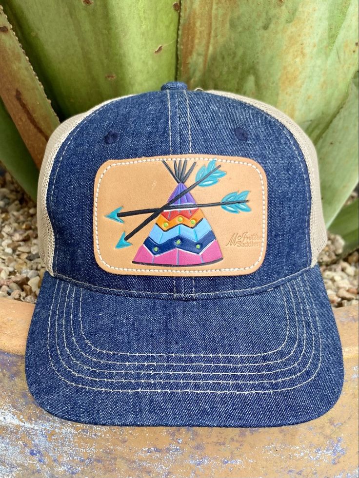 Ladies Cap Denim/Tan/Purple/Blue Tan Mesh Back Hand Tooled & Painted Leather Teepee Patch Casual Baseball Cap With Leather Patch, Casual Purple Snapback Trucker Hat, Casual Purple Baseball Cap With Curved Bill, Adjustable Denim Snapback Trucker Hat, Adjustable Denim Trucker Hat Snapback, Spring Casual Trucker Hat With Flat Bill, Spring Casual Flat Bill Trucker Hat, Casual Denim Trucker Hat, Purple Adjustable Trucker Hat