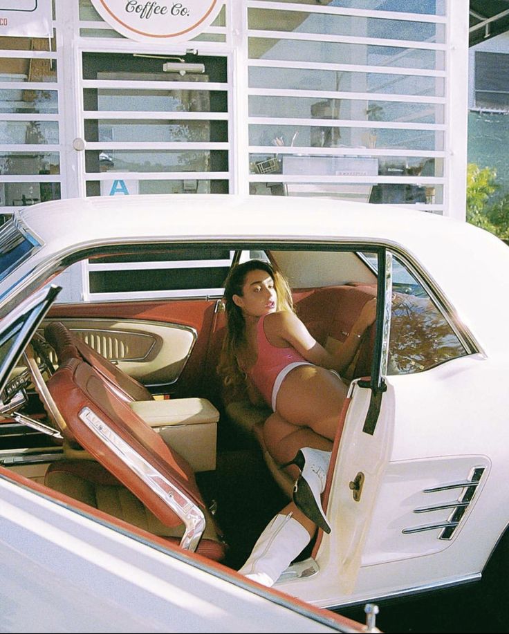 a woman sitting in the driver's seat of a car