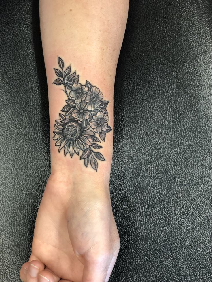 a black and white flower tattoo on the wrist