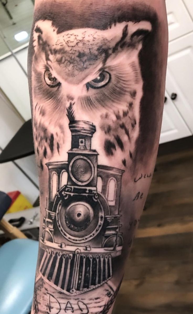 an owl and train tattoo on the arm