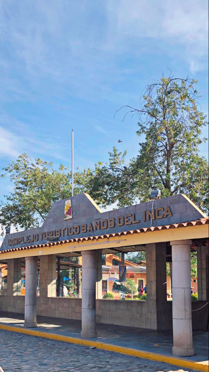 the entrance to an old building with flags on it's roof and pillars in front