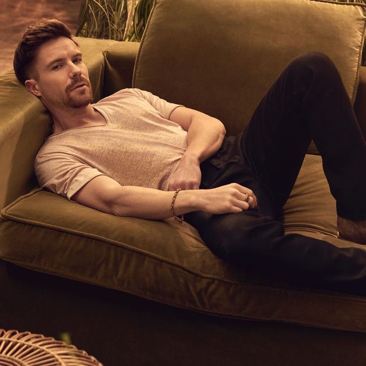 a man laying on top of a brown couch