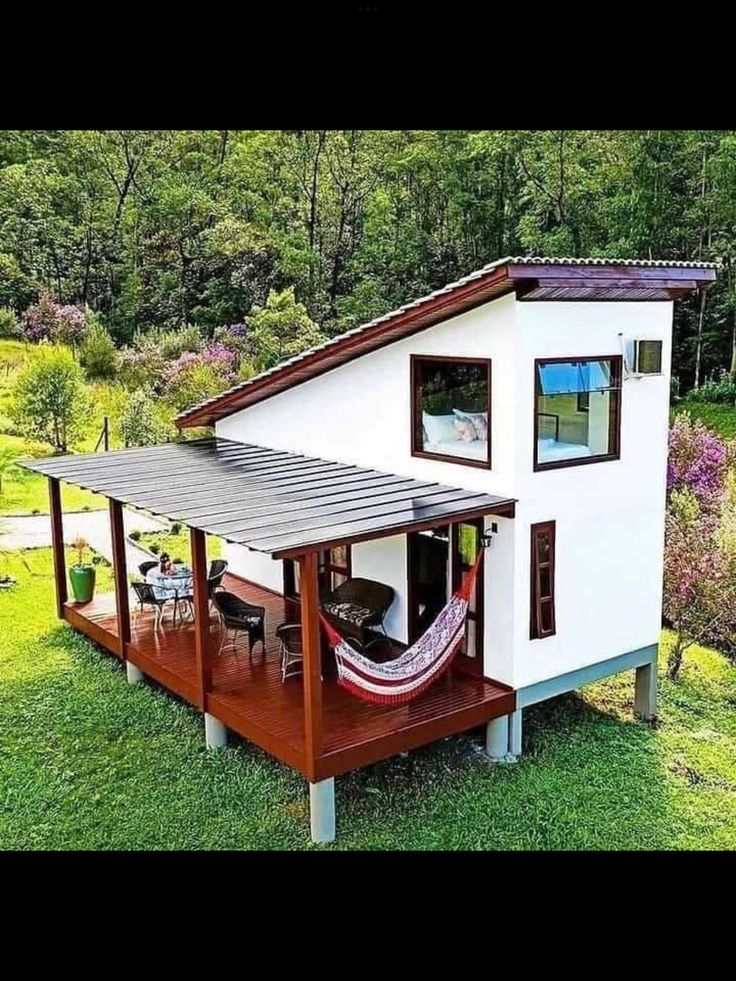 a small house with a hammock hanging from the roof