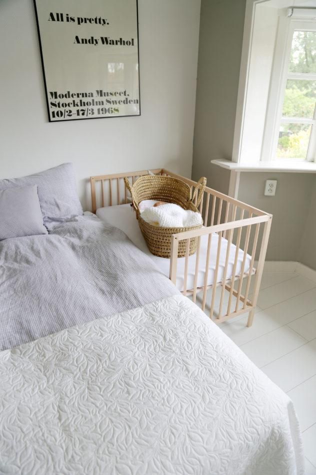 a baby crib in the corner of a room with a poster on the wall