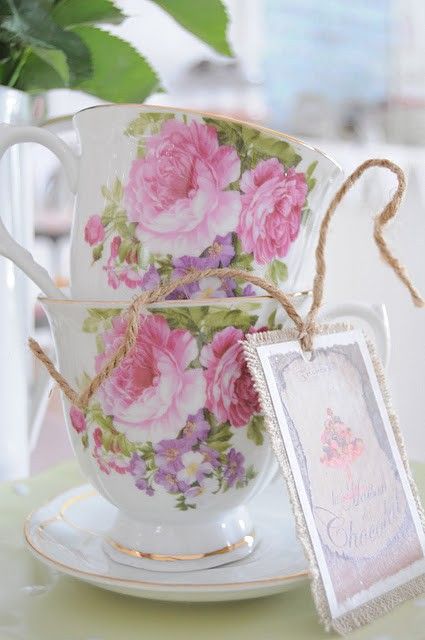 a tea cup and saucer on a table with a tag attached to the handle